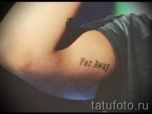 Фото тату на руке с надписью 'Far Away', выполненной простым шрифтом. Рисунок выполнен в коричневых тонах.