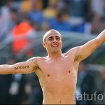 Фото спортсмена с татуировкой на плече, выполненной в чёрно-белой гамме. Изображены надписи на иностранном языке.