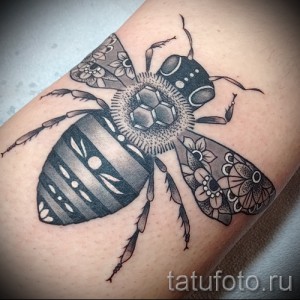 Фото тату пчелы с геометрическими узорами и точками на руке. Черно-белый рисунок татуировки с высокой детализацией.
