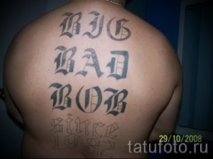 Фото тату: большая надпись 'BIG BAD BOB since 1982', выполненная в готическом стиле, на спине мужчины. Впечатляющая и запоминающаяся татуировка.