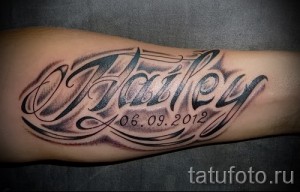 Фото тату на предплечье: имя 'Hailey' и дата '06.09.2012', выполненные в черно-серых тонах с декоративными элементами.