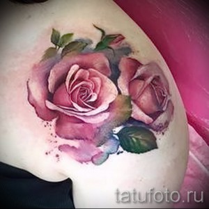 Фото тату: акварельные розы на плече, нежные розовые и фиолетовые оттенки, размытые края, реалистичный рисунок татуировки.