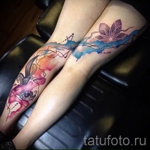 Фото парных акварельных татуировок на икрах, изображающих птицу и лист, выполненных в нежных пастельных тонах.