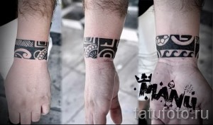 Фото тату в стиле маори на запястье, выполненного в черном цвете. Традиционные спиральные узоры и символы, характерные для культуры маори.