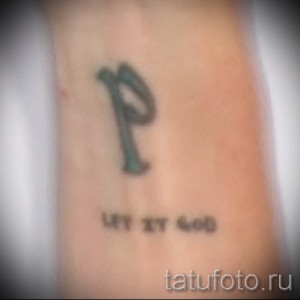 Фото тату: буква 'P' и цифры '07.17.90' на предплечье. Классический рисунок татуировки, выполненный в темных тонах.