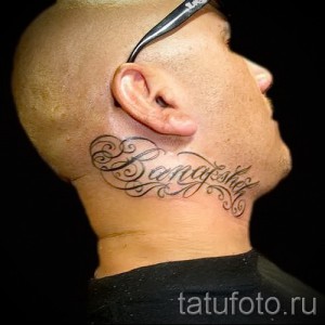 Фото тату имени "Bennygshol" на шее мужчины. Черные чернила, каллиграфический шрифт, декоративные элементы. Идеи для тату имен в каллиграфическом стиле.