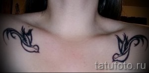 Фото тату двух ласточек на ключицах. Черно-белый рисунок, выполненный в минималистичном стиле, с изящными линиями.