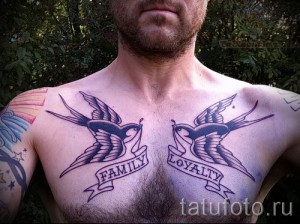Фото тату двух ласточек с надписями "Family" и "Loyalty" на груди. Символичный рисунок, посвященный семье и верности.