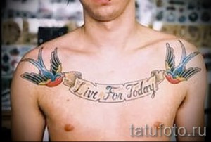 Фото тату на груди: две ласточки с надписью 'Live For Today' на ленте. Олдскульный стиль, вдохновляющий девиз.