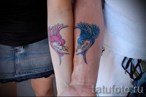 Фото парных татуировок ласточек на запястьях. Одна ласточка в розовых тонах, другая – в синих, с датой '09.09.09'.