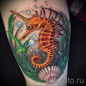 Фото тату морского конька на предплечье. Детализированный рисунок с использованием ярких оранжевых, зеленых и голубых цветов. Эскиз татуировки в стиле реализм.
