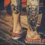 Фото татуировки на голени, сочетающей в себе изображение черепа, японские волны и традиционные узоры. Черно-белое изображение.