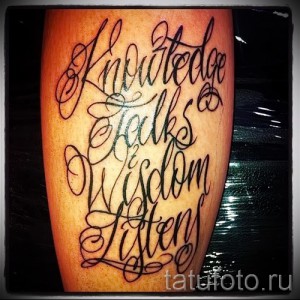 Фото тату с каллиграфической надписью "Knowledge speaks, Wisdom listens" на руке. Рисунок выполнен в черных чернилах с изящными завитушками.