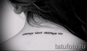Фото тату на шее с надписью "DESTROY WHAT DESTROYS YOU". Простая и лаконичная татуировка с мотивационным текстом.