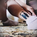 Фото тату двух силуэтов кошек на лодыжке. Черный рисунок татуировки выполнен в минималистичном стиле, идеально подходит для любителей кошек.