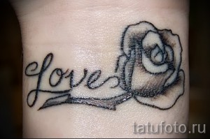 Фото тату: Черно-белая татуировка розы и надписи "love" на запястье, минималистичный стиль, каллиграфический шрифт.