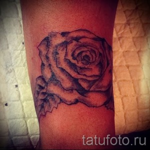 Фото минималистичной черно-серой татуировки розы на руке. Простой и элегантный дизайн с использованием тонких линий и теней.