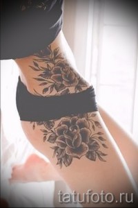 Фото тату с изображением роз на бедрах в стиле blackwork. Детализированный рисунок татуировки, выполненный полностью в черном цвете, с использованием различных техник затенения.