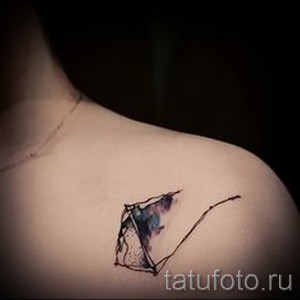 Фото акварельного тату зонта на плече. Нежный, красочный рисунок татуировки с размытыми краями.