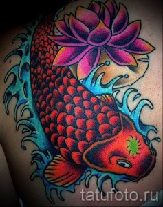 Фото тату: красочный карп кои с лотосом, выполненный в традиционном японском стиле, украшает плечо.