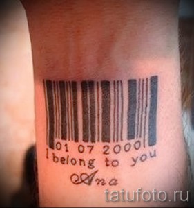 Фото тату штрихкода на предплечье с датой '01 07 2000' и надписью 'I belong to you Ana'. Черно-белый рисунок татуировки.