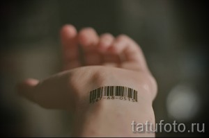 Фото тату штрихкода на ладони с номером '1367-68-0515'. Черно-белый минималистичный рисунок татуировки.