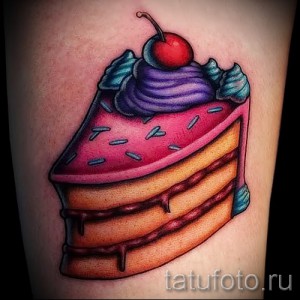 Фото тату куска торта с вишней и кремом на руке. Яркие цвета, реалистичный стиль.