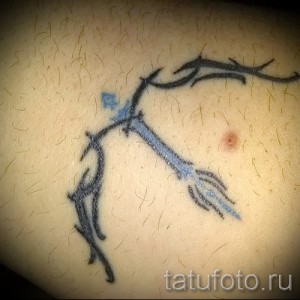 Фото минималистичной тату с изображением головы кентавра. Черно-белый контурный рисунок, расположенный на животе.