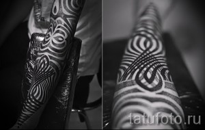 Фото тату на ноге: сложный узор в стиле dotwork, состоящий из спиралей и геометрических фигур. Детализированный рисунок татуировки в черном цвете.
