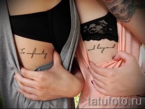 Фото парных татуировок с надписями 'To infinity and beyond' на боках двух девушек, выполненных изящным шрифтом.