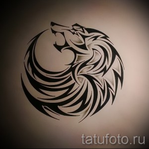 Черно-красная татуировка ворона в круге, выполненная в графическом стиле на предплечье. Изображение символизирует свободу и мистику.
