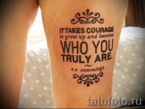 Фото татуировки с мотивирующей надписью "It takes courage to grow up and become who you truly are" на женском бедре.