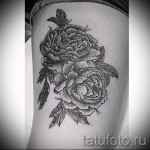 Фото тату букета пионов, выполненного в технике dotwork, на женском бедре. Рисунок выполнен в черно-белой гамме с использованием множества точек.
