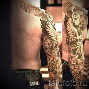 Фото тату ангела с большими белыми крыльями на плече, выполненное в реалистичном стиле с использованием светлых и темных оттенков.