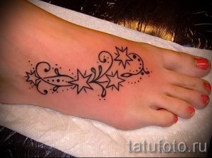 Фото тату: небольшая черная татуировка в виде звезд и волн на верхней части стопы. Простой и элегантный рисунок татуировки.