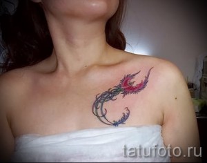 Фото тату феникса на ключице. Красивый рисунок птицы с ярким оперением, выполненный в технике сочетающей графику и акварель.