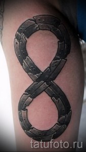 Фото тату: знак бесконечности, выполненный в технике blackwork на руке. Грубые линии и эффект состаренности.