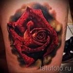 Фото тату реалистичной красной розы на бедре. Сочные цвета и детализированная проработка лепестков.