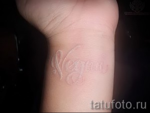 Фото белой татуировки с надписью "Regina" на женском запястье. Имя, выполненное в технике white tattoo.