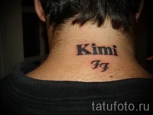 Фото татуировки с именем 'Kimi' и инициалами 'FF' на затылке. Черно-красный рисунок татуировки, выполненный простым шрифтом.