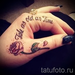 Фото тату на руке с изображением розовой розы и надписью "Take as old as Time". Нежный рисунок татуировки для девушек.