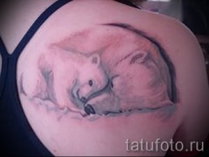 Фото тату с изображением двух белых медведей на плече, выполненного в мягких розовых и серых тонах. Детализированный рисунок с эффектом объема.