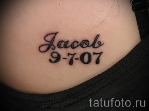 Фото тату: небольшая татуировка с именем 'Jacob' и датой '9-7-07' на животе.