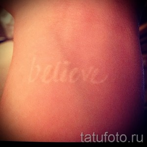 Фото тату: Надпись 'Believe' белыми чернилами на руке. Каллиграфический шрифт и нежный дизайн.