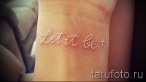 Фото белой татуировки с надписью 'Let it be' на запястье. Простой, но вдохновляющий рисунок, выполненный каллиграфическим шрифтом.