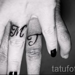 Фото парных татуировок на пальцах: две руки с татуировками инициалов 'M' и 'J' выполненных черным контуром. Простой и элегантный дизайн.