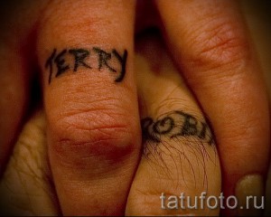 Фото парных татуировок на пальцах: надписи 'Jerry' и 'Rosa' выполненные черным контуром. Простой и лаконичный дизайн.