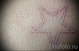 Фото двух белых татуировок в виде звезд на стопе. Минималистичный и символичный рисунок.