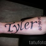 Фото тату имени «Tyler» и даты «04-06-00» на руке. Татуировка выполнена в классическом стиле с использованием черных линий.