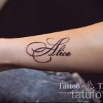 Фото тату имени «Alice» на руке. Татуировка выполнена в каллиграфическом стиле с использованием коричневых оттенков.